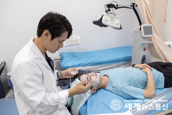 지난달 6일 한국 의사 홍석경이 여드름 환자에게 중의학 마스크팩을 도포하고 있다. (사진/신화통신)